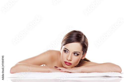 Portrait of beautiful young woman lying down on towel