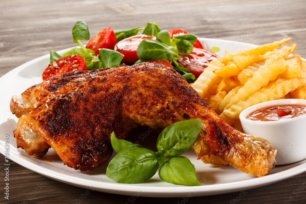Grilled chicken legs with chips and vegetables