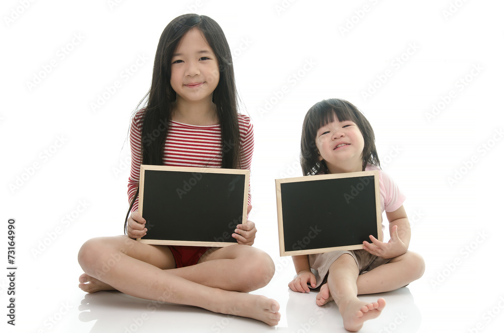 Little asian boy and girl sitting and holding chalkboard Little asian boy and girl sitting and holding chalkboard