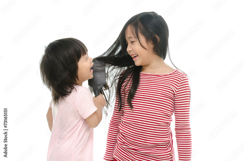 Little asian boy smiling and brushing sister hair Little asian boy smiling and brushing sister hair