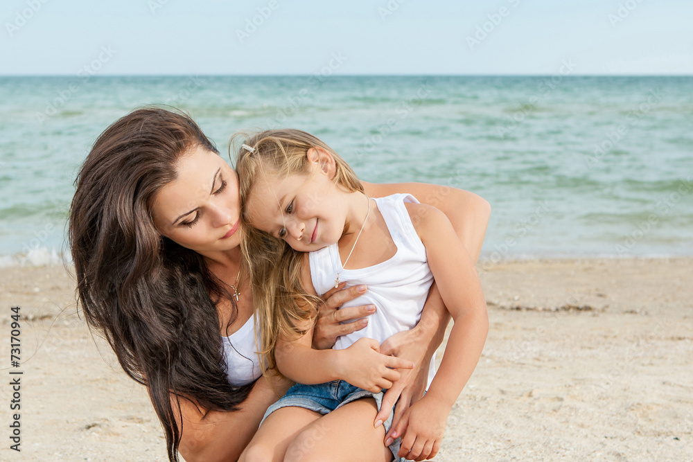 Mother and her daughter  having fun on the beach