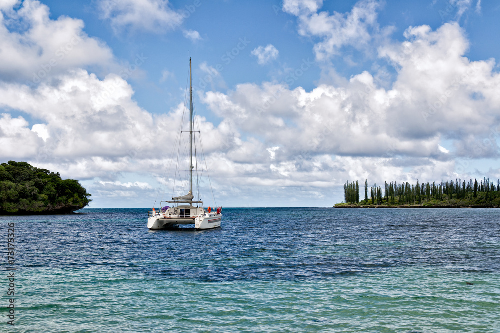 Obraz premium Sailboat in the South Pacific under a cloudy blue sky