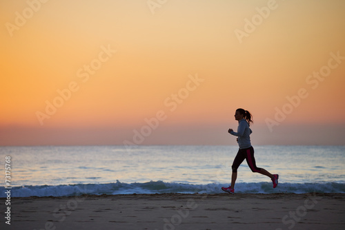 fitness woman running on beach