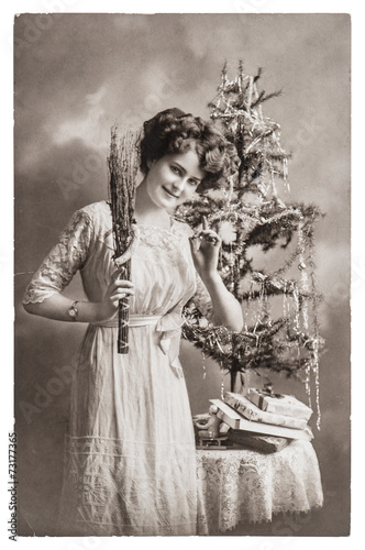 young woman with christmas tree and gifts. antique picture