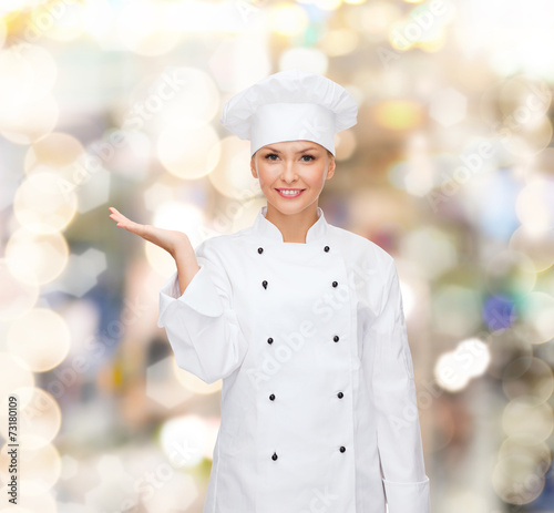 smiling female chef holding something on hand