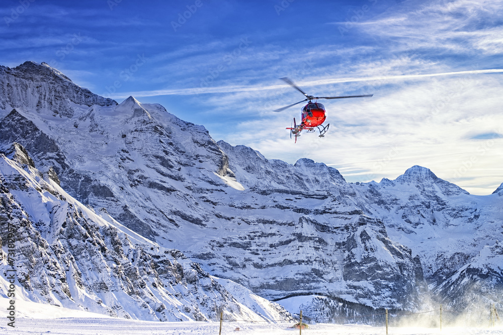 Red helicopter flying at swiss alps near Jungfrau mountain Red helicopter flying at swiss alps near Jungfrau mountain