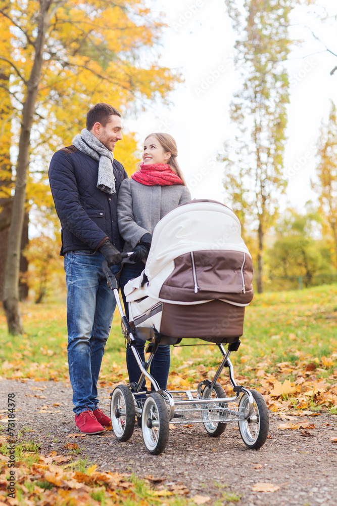 smiling couple with baby pram in autumn park smiling couple with baby pram in autumn park