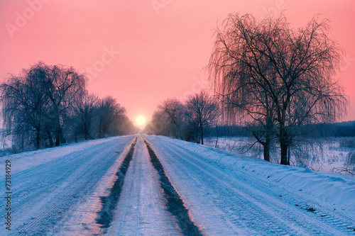 Beautiful pink sunrise over snowy road © vvvita