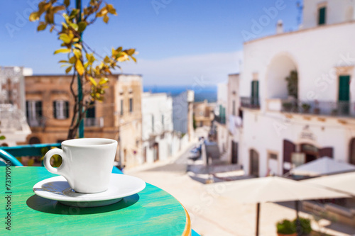 Fototapeta Naklejka Na Ścianę i Meble -  A cup of coffee on table with Italian town at the background