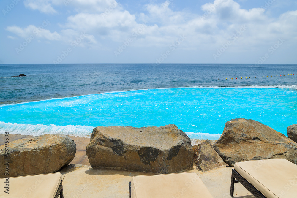 Fototapeta premium Sunbeds with lava rocks and swimming pool, Madeira island
