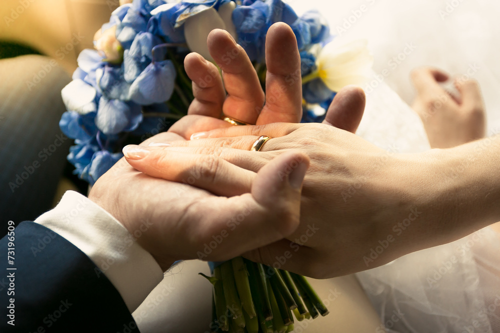 photo of groom holding brides hand in car
