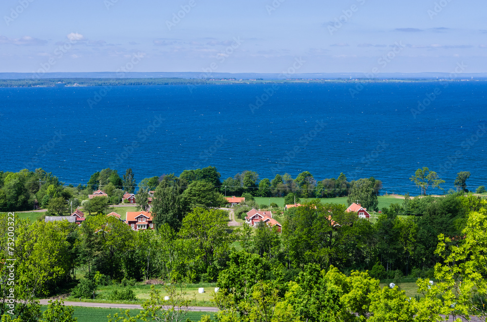 View of a lush landscape and the lake Vättern.