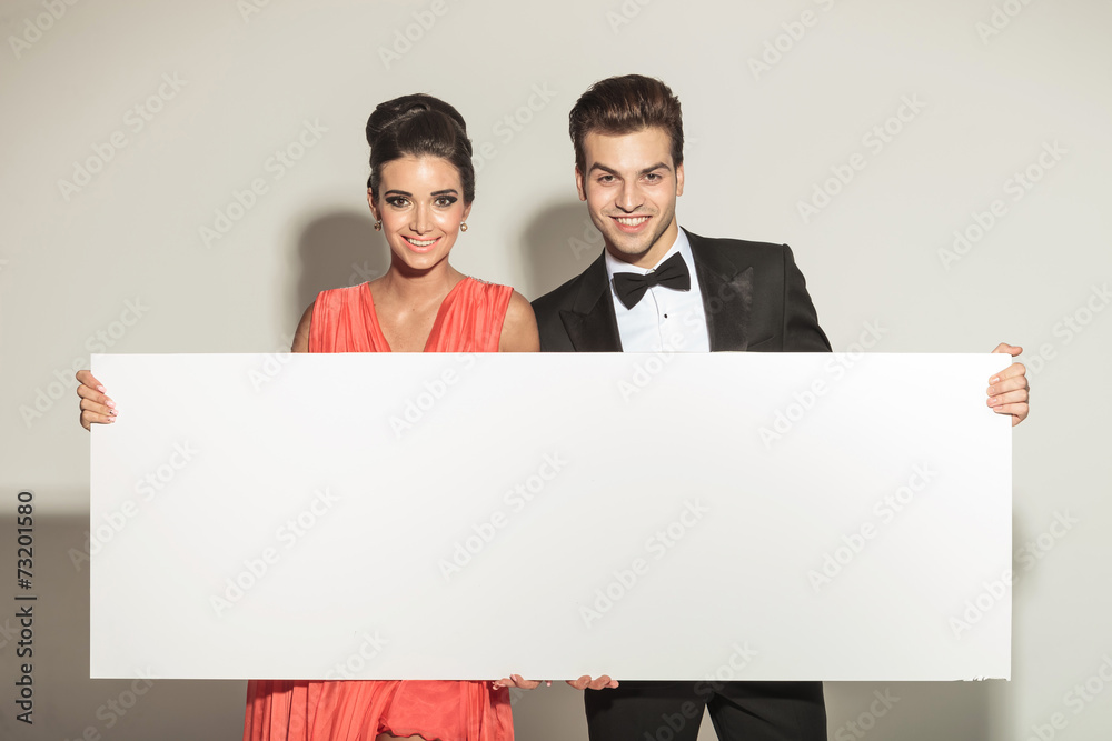 elegant couple smiling while holding a white board elegant couple smiling while holding a white board