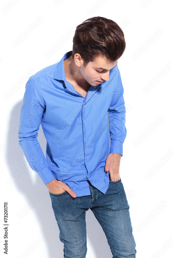 Fashion man looking down while putting his hand in pocket.