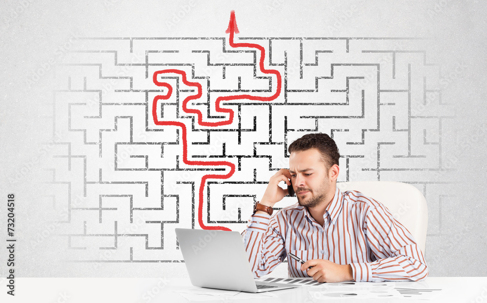 Business man at desk with labyrinth and arrow Business man at desk with labyrinth and arrow