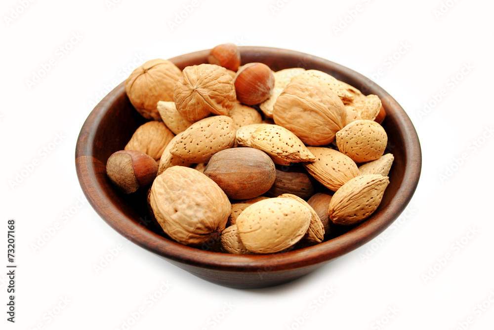 Mixed Whole Nuts in a Wooden Bowl Over White Mixed Whole Nuts in a Wooden Bowl Over White