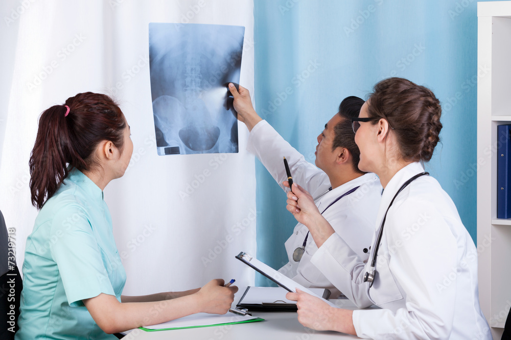 Diverse doctors analyzing patient's x-ray Diverse doctors analyzing patient's x-ray
