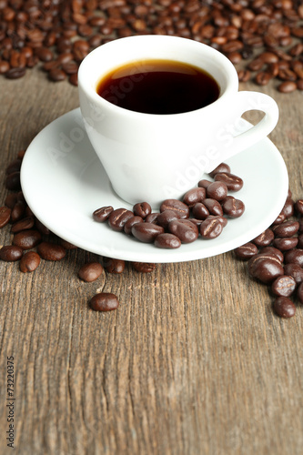 Cup of coffee and coffee beans with chocolate glaze
