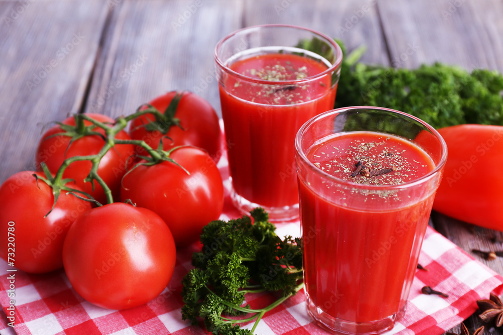 Tomato juice in glasses and fresh vegetables Tomato juice in glasses and fresh vegetables