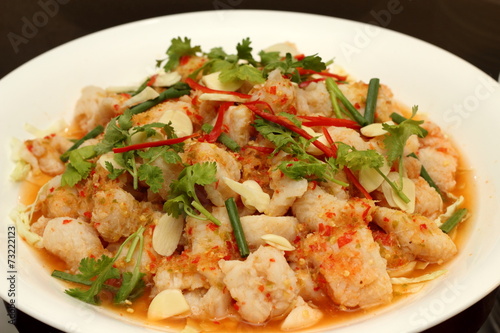 Spicy salad with  shrimp, fish and vegetables on white dish. © mitrs3