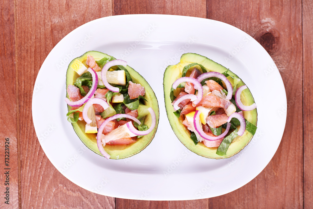 Tasty salad in avocado on plate table close-up Tasty salad in avocado on plate table close-up