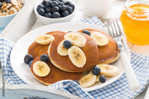 pancakes with banana, honey and blueberries for breakfast