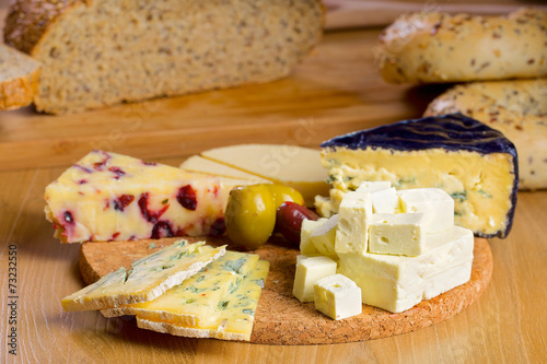 Various cheese and olives on a wooden board