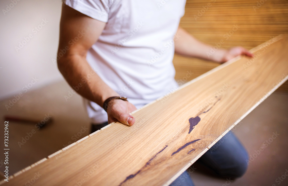 Handyman installing wooden floor - obrazy, fototapety, plakaty 