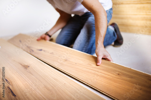 Handyman installing wooden floor photo