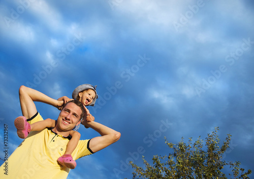 Father and daughter against the sky