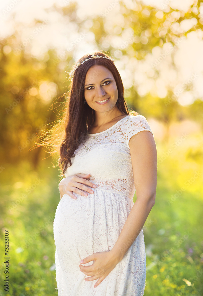 Pregnant woman in white dress in nature Pregnant woman in white dress in nature
