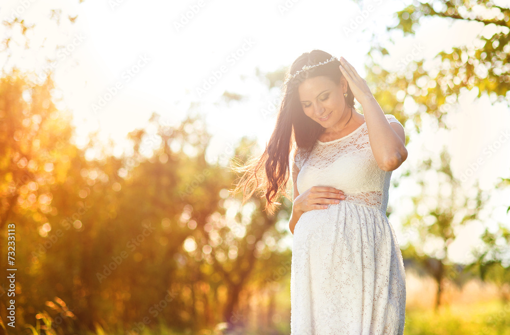 Pregnant woman in white dress in nature Pregnant woman in white dress in nature