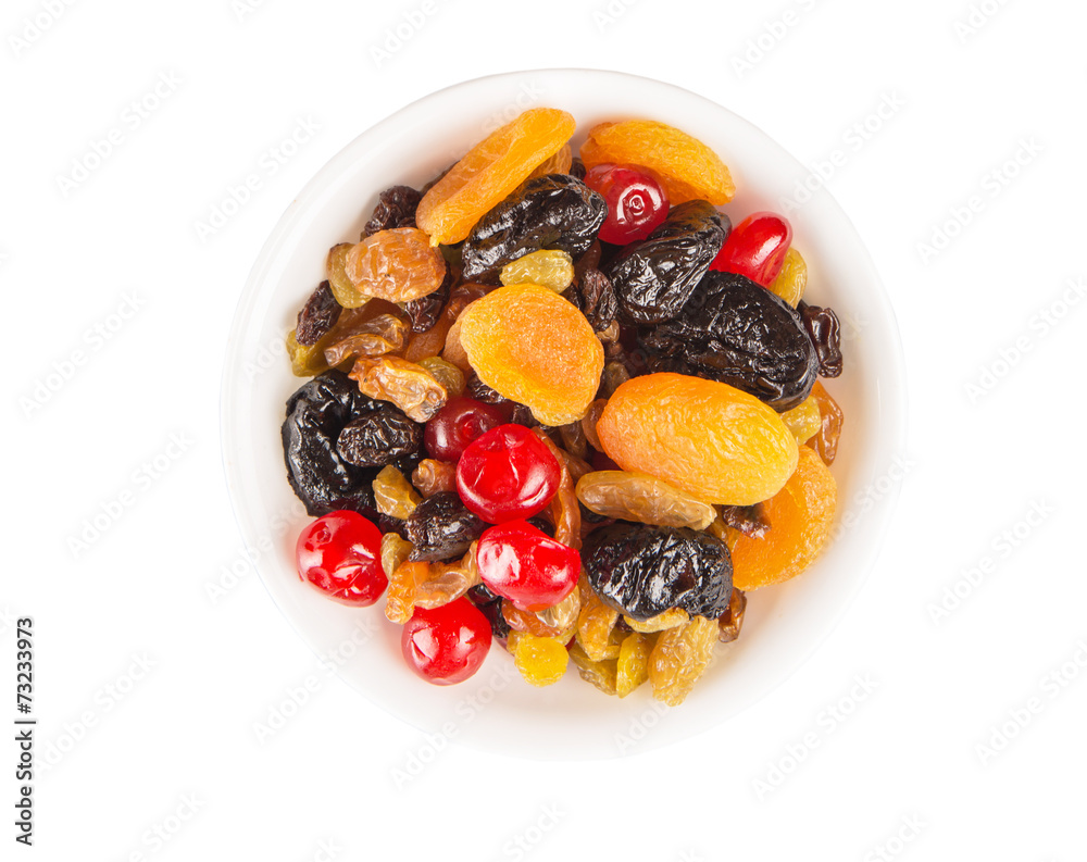 Mix variety of dried fruit in white bowl over white background