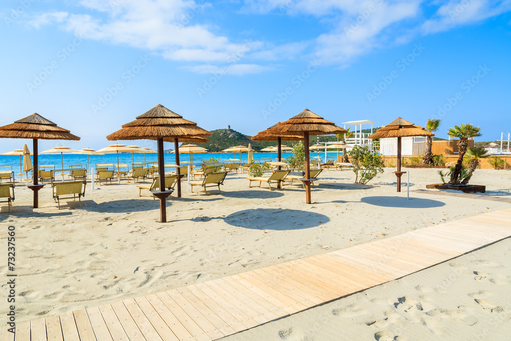 Sunchairs with umbrellas on Porto Giunco beach, Sardinia island