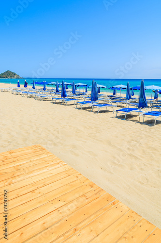 Wooden walkway and sunbeds on Cala Sinzias beach  Sardinia