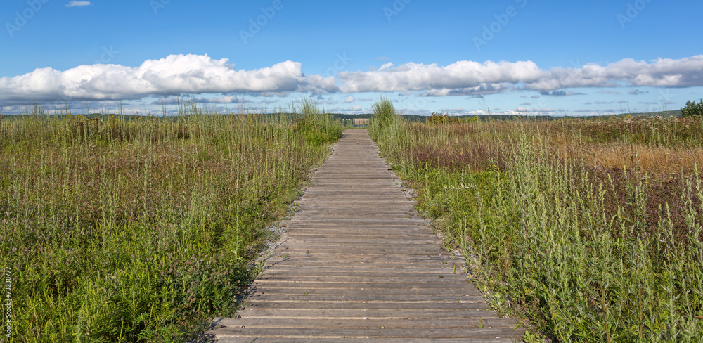 Obraz premium Old walkway towards blue cloudy sky