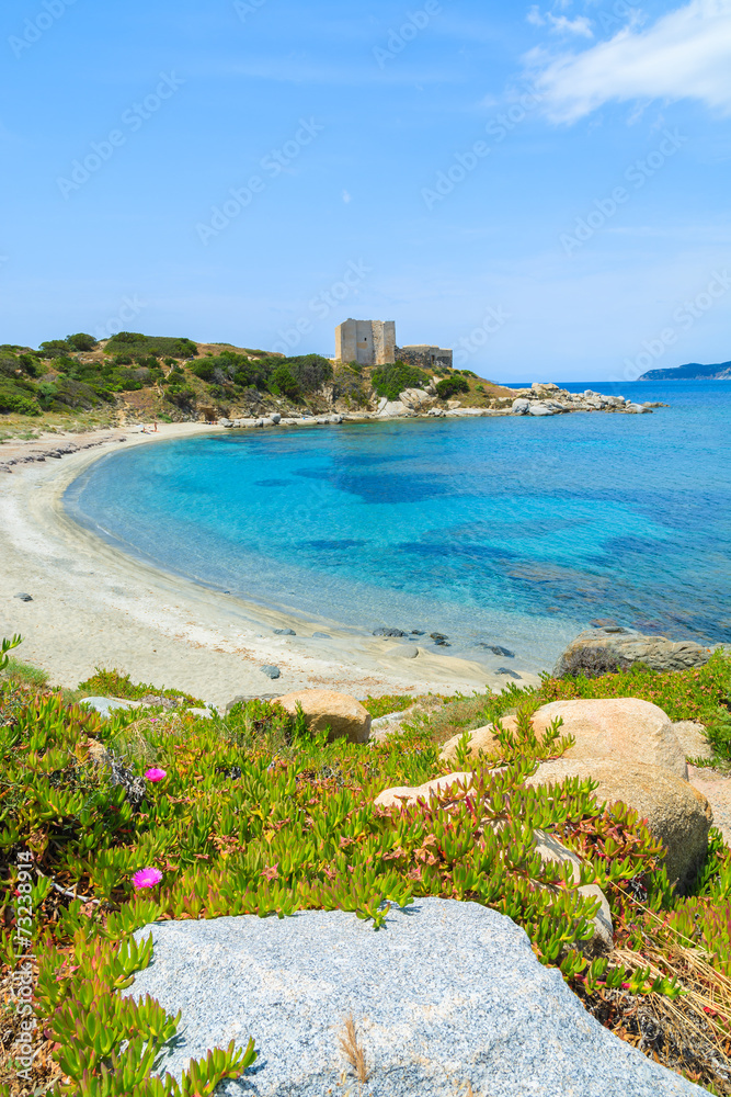 Beach with azure sea and castle on coast of Sardinia island