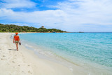 Young woman walking on white sand beach, Cala Pira, Sardinia