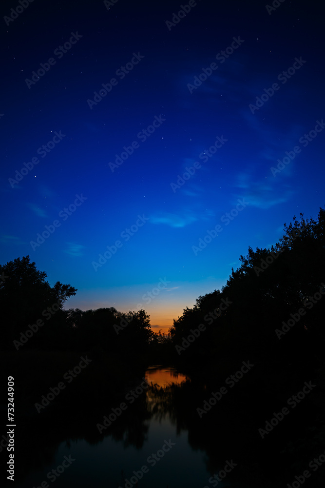 Illuminated by the sun clouds at sunset on a background of blue sky