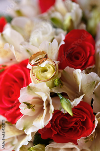 Gold wedding rings on a bouquet of flowers for the bride