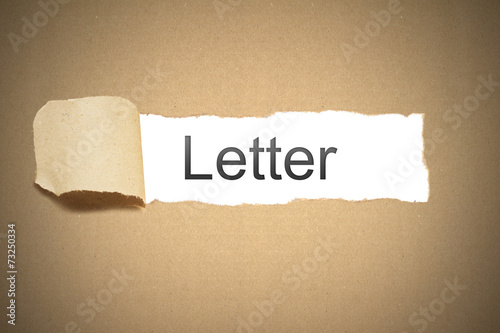 brown package paper torn to reveal white space letter