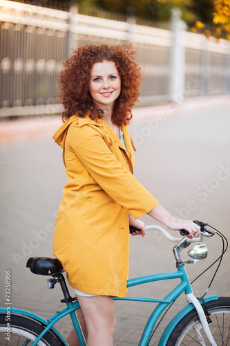 Cute girl on a vintage bike in the city