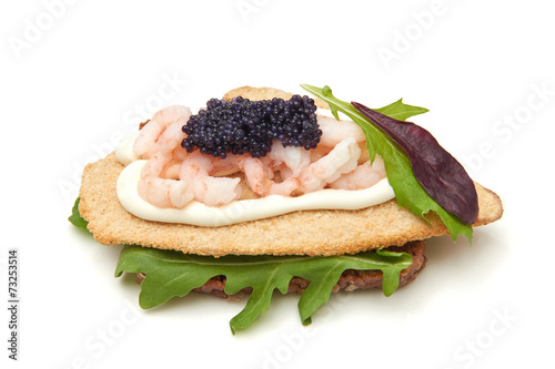 Dark rye bread topped with breaded fish photo