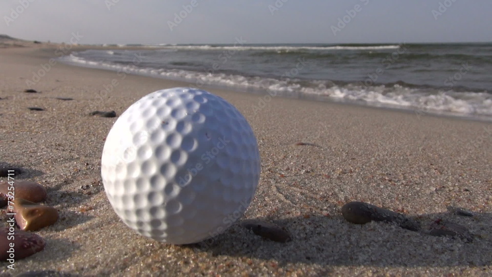 golf ball on sea resort beach sand - leisure concept golf ball on sea resort beach sand - leisure concept