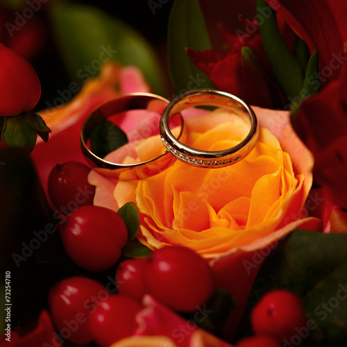 Gold wedding rings on a bouquet of flowers for the bride