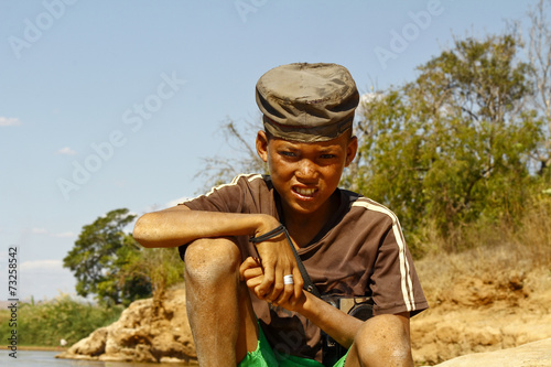 Photo of adorable young happy boy - african poor child on the ri
