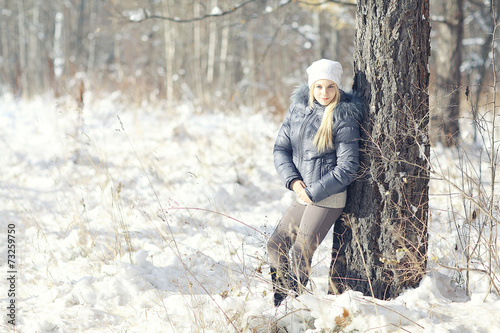 portrait of a young blonde girl in winter forest in the park