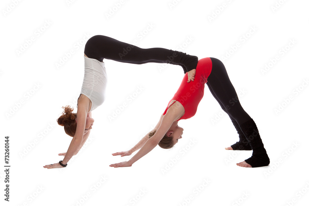 Two girls doing yoga on a white background Two girls doing yoga on a white background