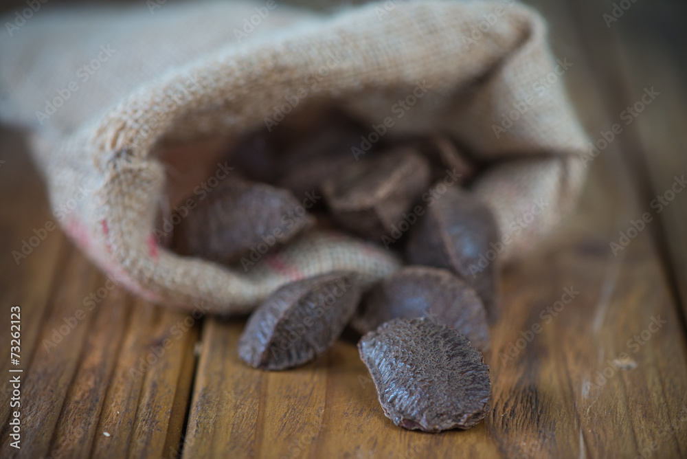 Obraz premium Brazilian nuts in sack on table