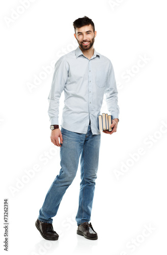 Young bearded smiling man with books in hand on white